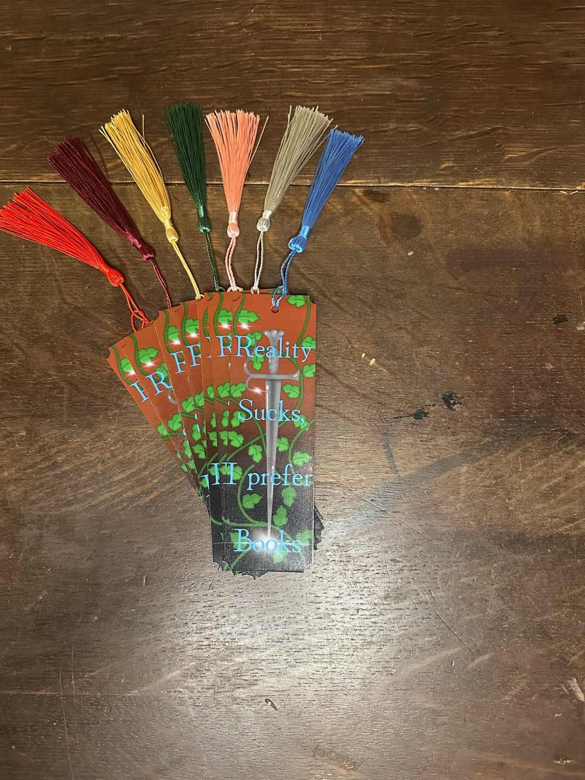Petty Pixie Paper sarcastic notepads arranged on a dark wood table